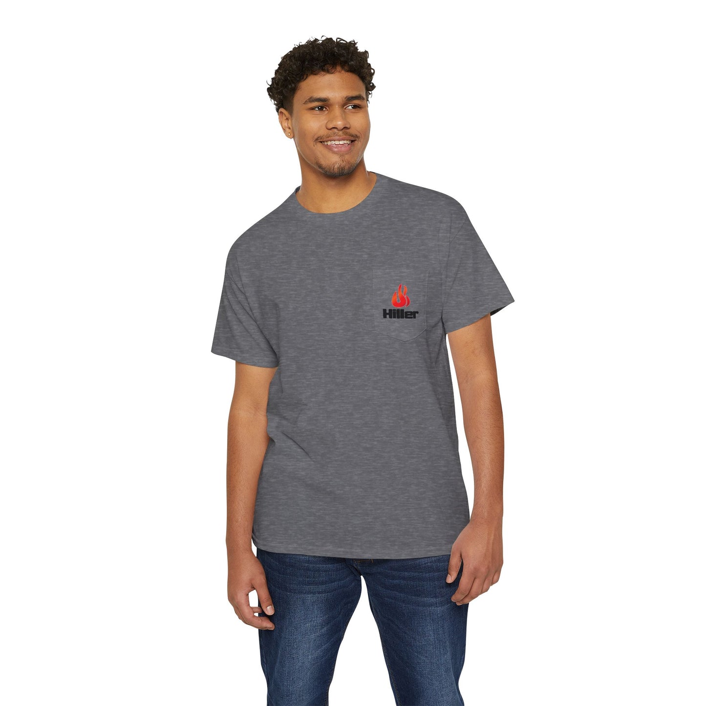 A smiling man stands against a white background wearing blue jeans and the gray Printify Unisex Heavy Cotton Pocket Tee, featuring Hiller Fire Guys graphics, highlighting the tee's versatility and soft fabric.