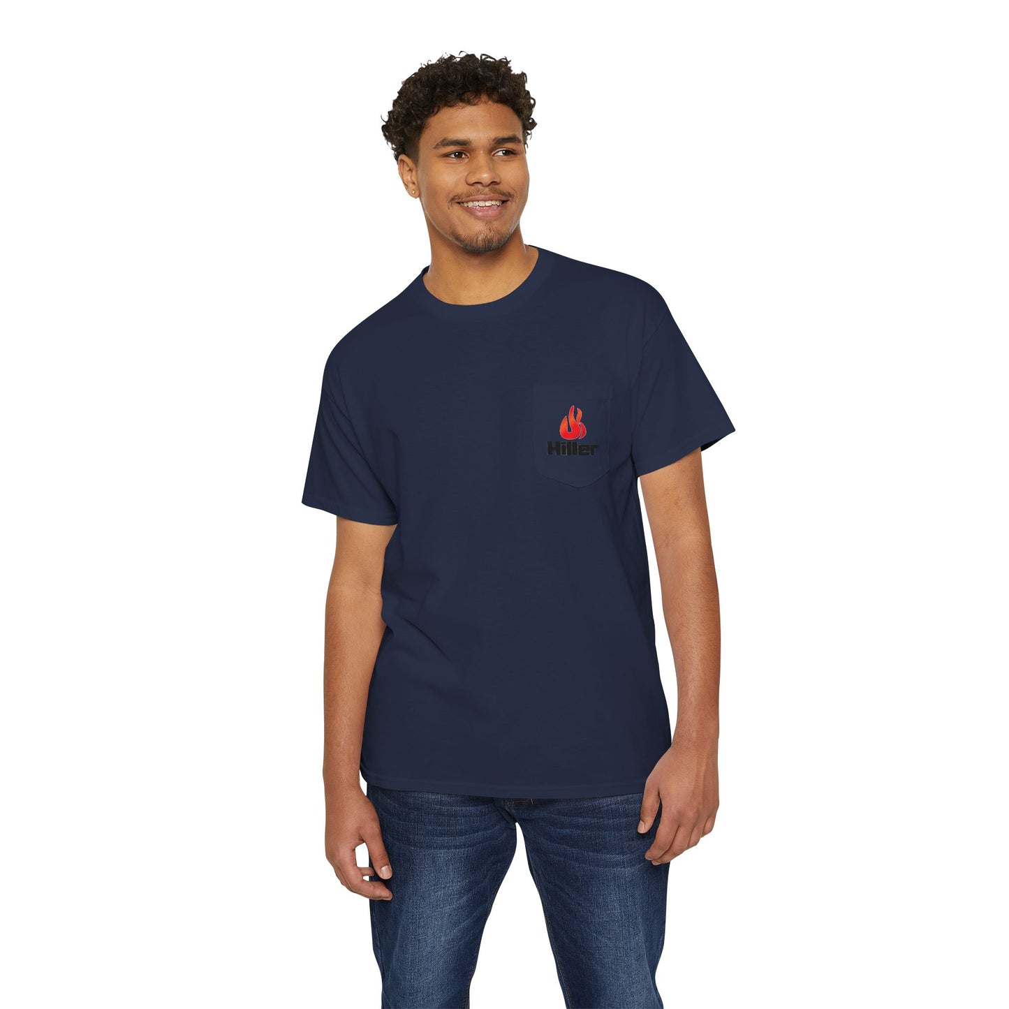 A man wears a navy blue T-shirt featuring the Printify Hiller Fire Guys design, paired with blue jeans. The versatile, lightweight tee sports a red flame logo and "Hitter," as he stands smiling against a white background.