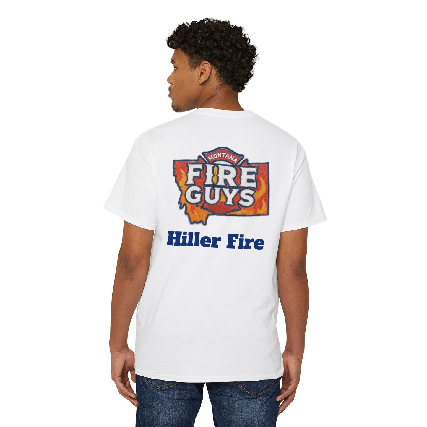 During an outing, the person wears a comfortable Printify Unisex Heavy Cotton Pocket Tee. It features the "Montana Fire Guys" logo and "Hiller Fire" text on the back as they stand casually and look to the side.
