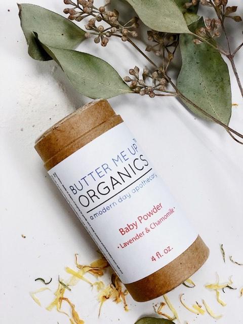 A container of "White Smokey All Natural Talc Free Baby Powder" with lavender and chamomile, surrounded by dried flowers and leaves on a white background. This talc-free baby powder provides a natural