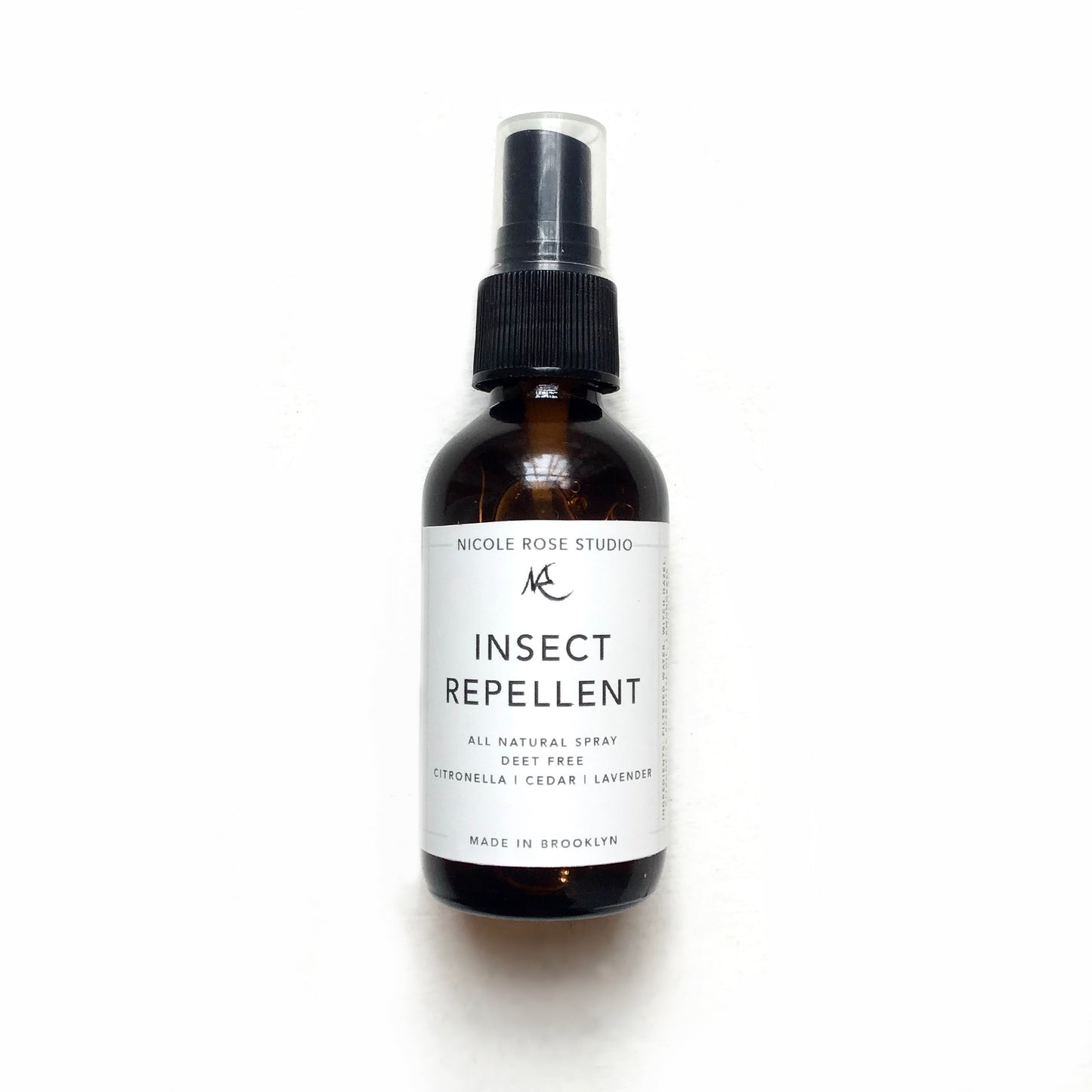 A brown spray bottle labeled "Indigo Poseidon All Natural Insect Repellent," featuring a DEET-free formulation with citronella, cedar, and lavender essential oils. The label proudly states it is made in Brooklyn, ensuring a natural mosquito insect repellent experience.