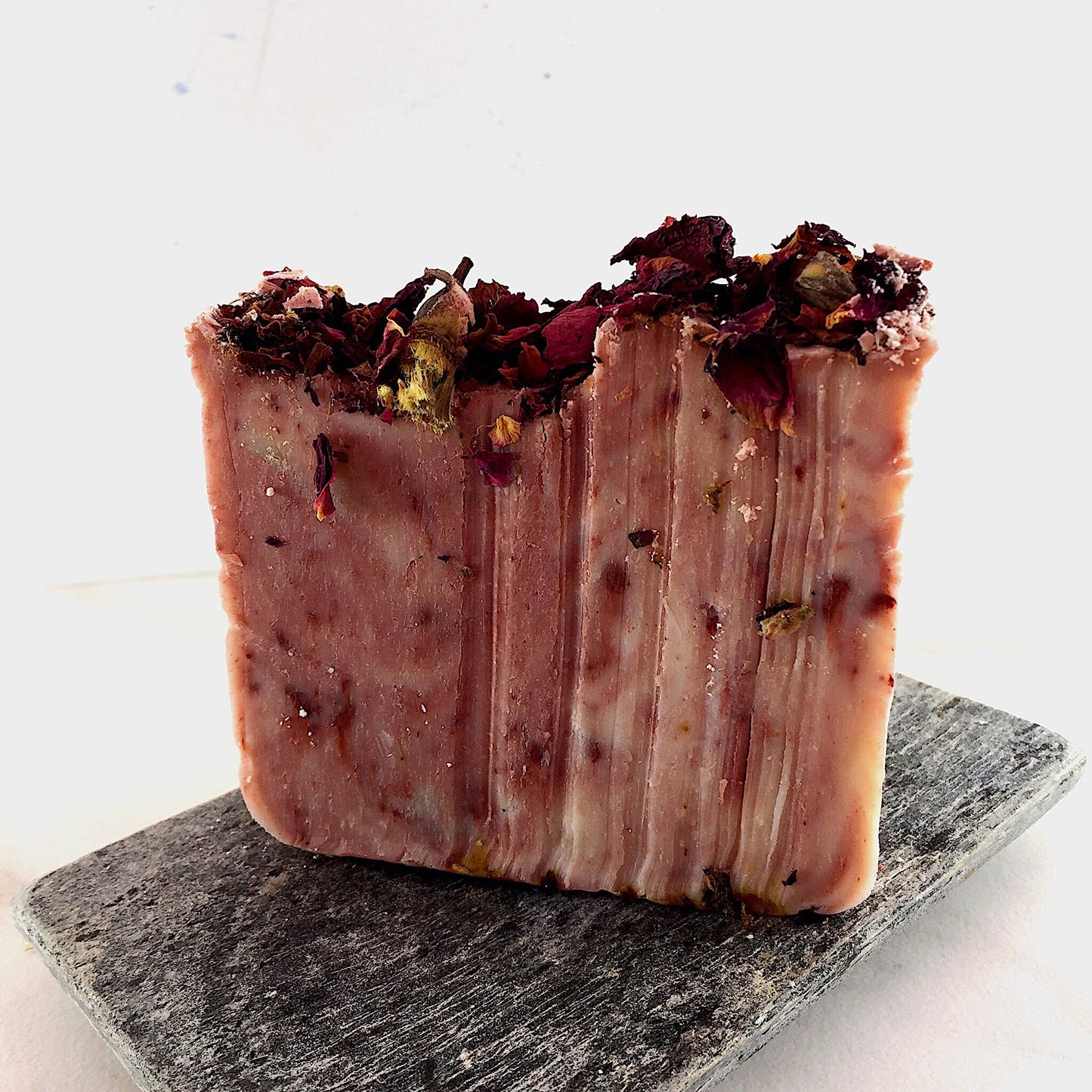 A natural bar of Rose Garden Organic Soap adorned with delicate rose petals, brought to you by White Smokey.