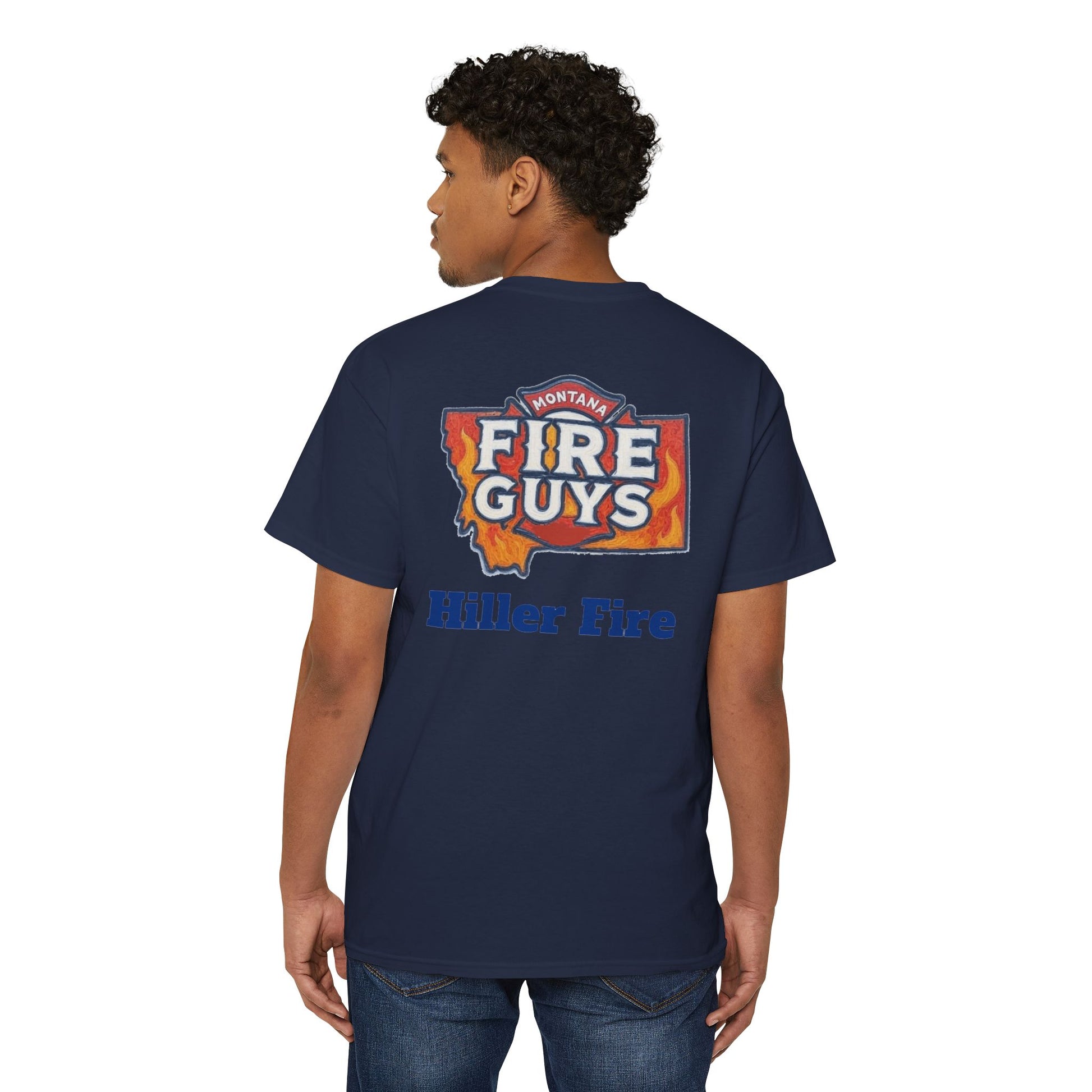 A man confidently stands wearing a navy Unisex Heavy Cotton Pocket Tee by Printify. With the "Hiller Fire Guys" graphic and "Hiller Fire" text on the back, this T-shirt is a comfortable and stylish staple for firefighters and outdoor enthusiasts. He glances over his shoulder with poise.