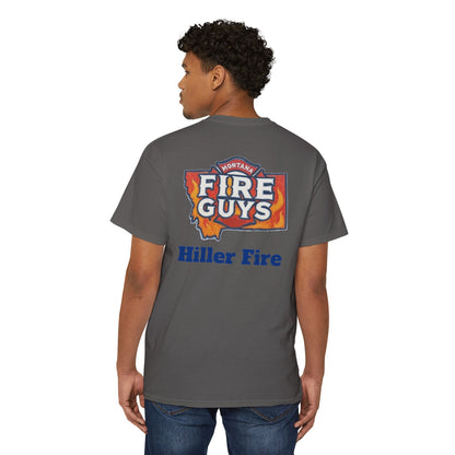Someone with curly hair is set for casual outings wearing a dark gray Printify Unisex Heavy Cotton Pocket Tee featuring the "Hiller Fire Guys" design. Paired with jeans, it's an ideal choice for outdoor activities.