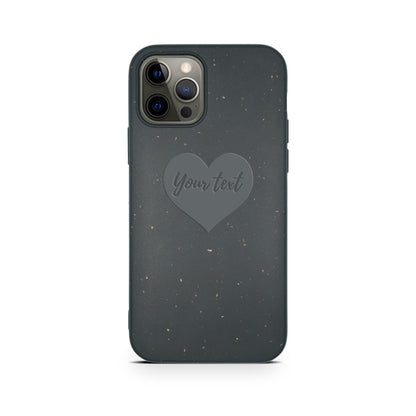 Dark grey, eco-friendly phone case featuring a heart design in the center with the words "Biodegradable Personalized Iphone Case - Black." The case has a speckled pattern and is designed for a phone with multiple camera lenses. Brand: Tan Lily.