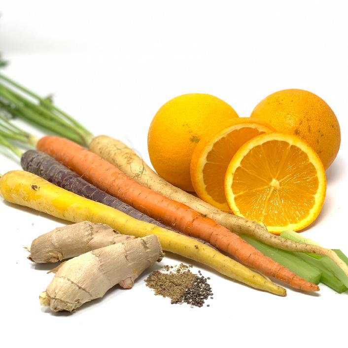 A selection of fresh orange halves, whole oranges, assorted colorful carrots, ginger roots, and a small pile of mixed spices on a white background, perfect for whipping up a vegan & gluten-free carrot ginger smoothie with the Brightening Exfoliating Mask by Cyan Ares.