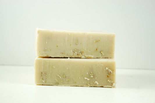Two rectangular bars of Maroon Oliver Oatmeal and Honey Facial Soap stacked on top of each other against a plain white background.
