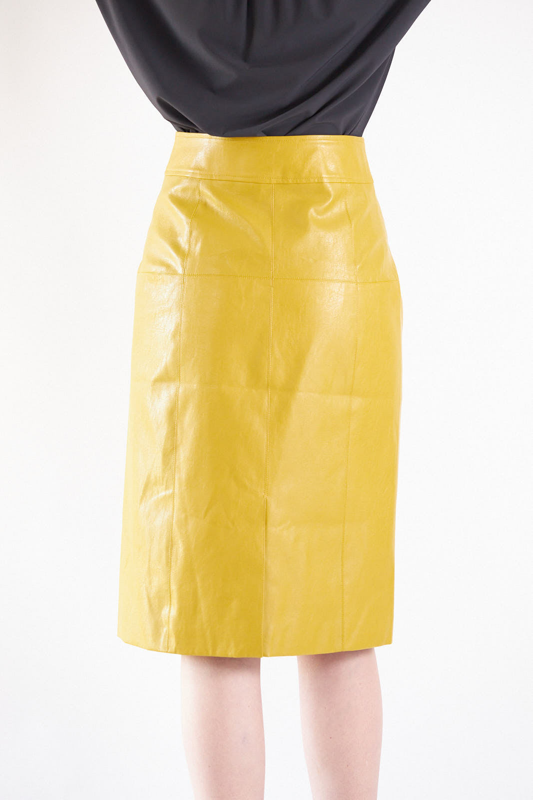Woman wearing a yellow Glossy Vegan Leather Pencil Skirt from Mauve Daisy against a white background.