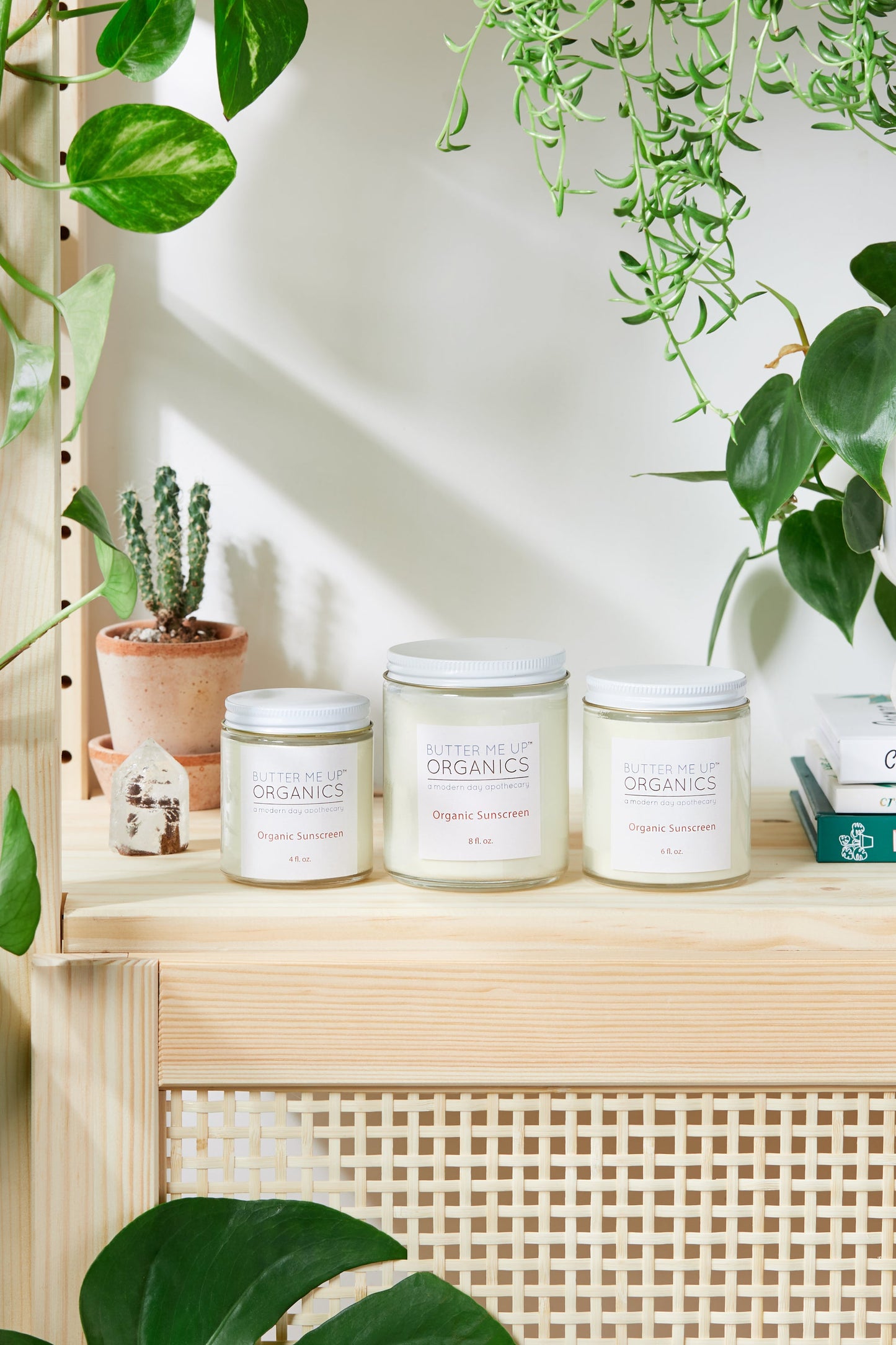 A shelf full of candles and plants on a shelf, with no toxic chemicals or White Smokey Natural Organic Sunscreen, Safe Sunscreen or Non-Nano Zinc Oxide SPF 45 Sunscreen present.