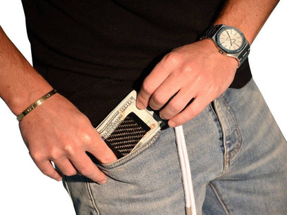 A man is holding a Green Angel Black Carbon Fiber Money Clip.