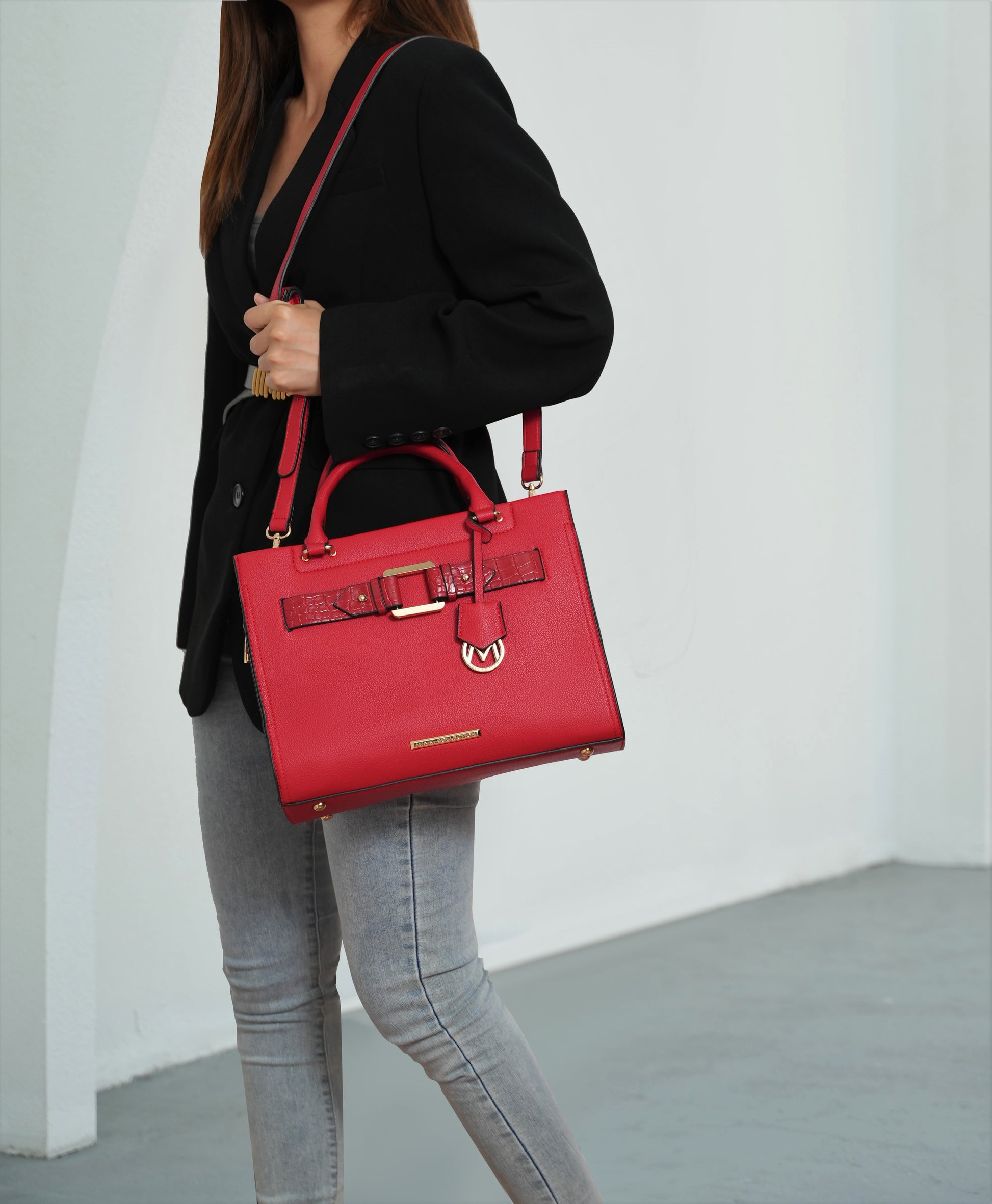 A woman wearing a black jacket and jeans with a Virginia Vegan Leather Women Tote Bag with Wallet featuring a crocodile-embossed finish from Pink Orpheus.