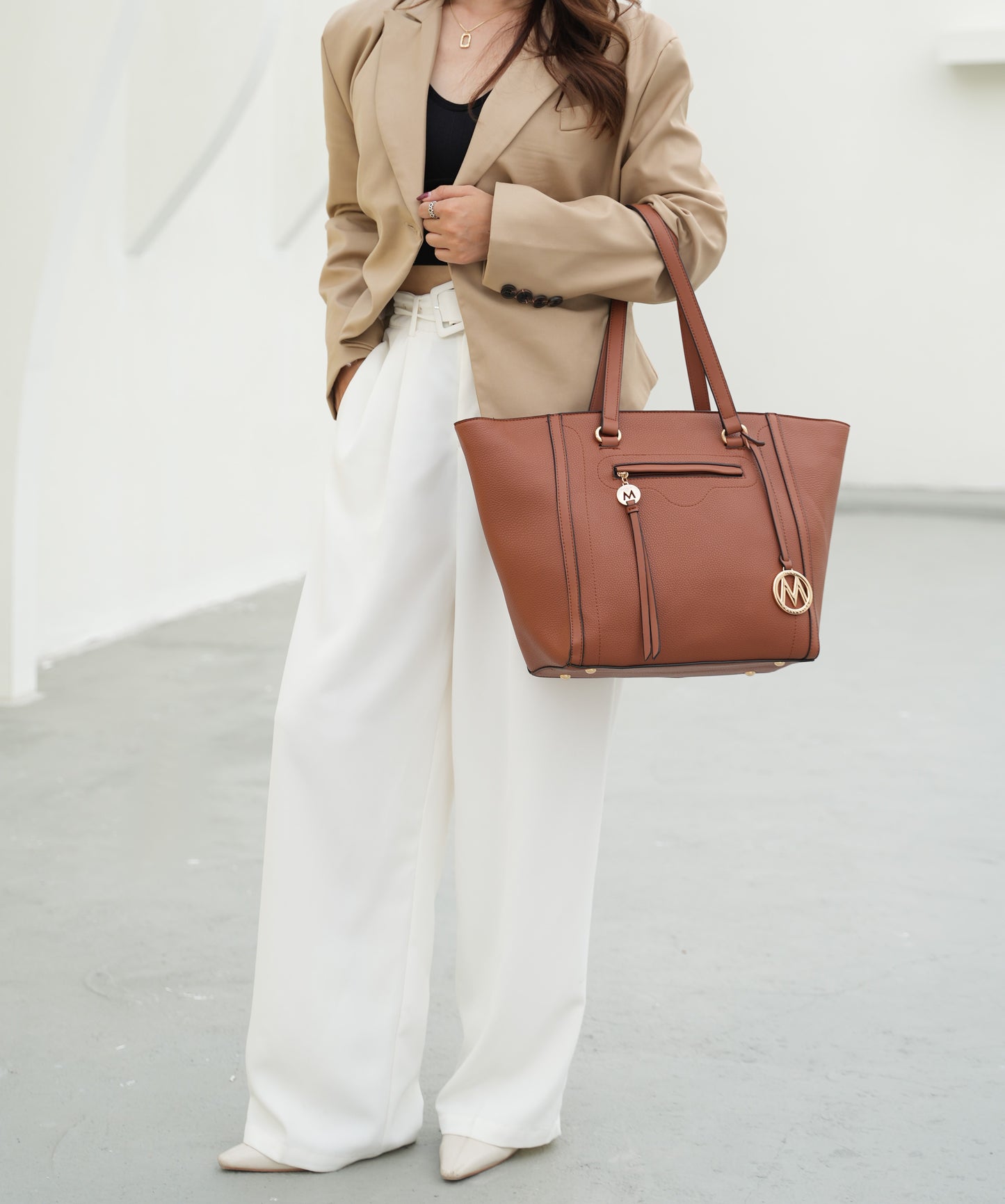 A woman wearing a tan blazer and white wide leg pants carrying a Pink Orpheus Alexandra Vegan Leather Women Tote Handbag with Wallet.