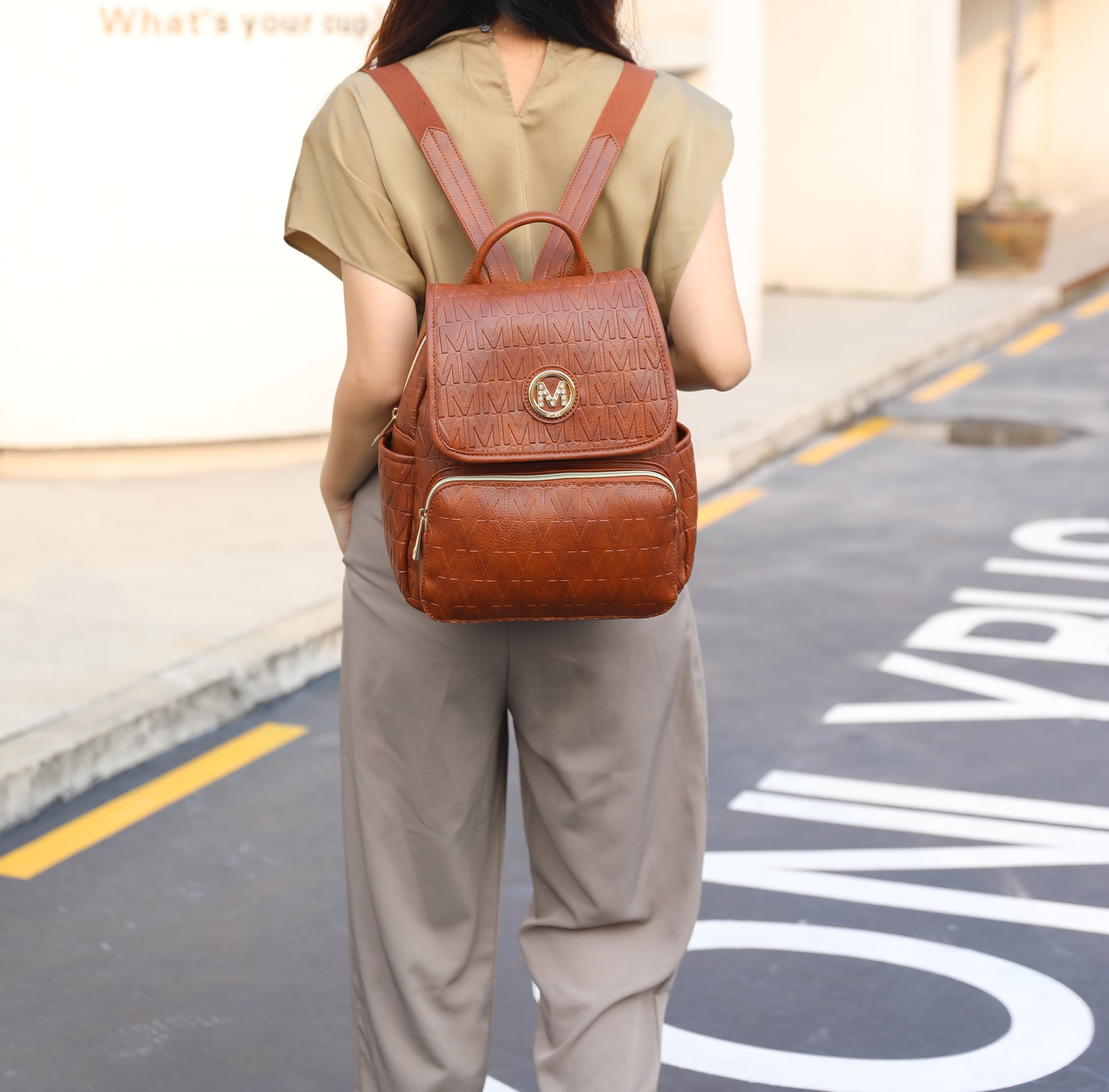 A woman walking down the street with a Samantha Backpack Vegan Leather Women made from Pink Orpheus.