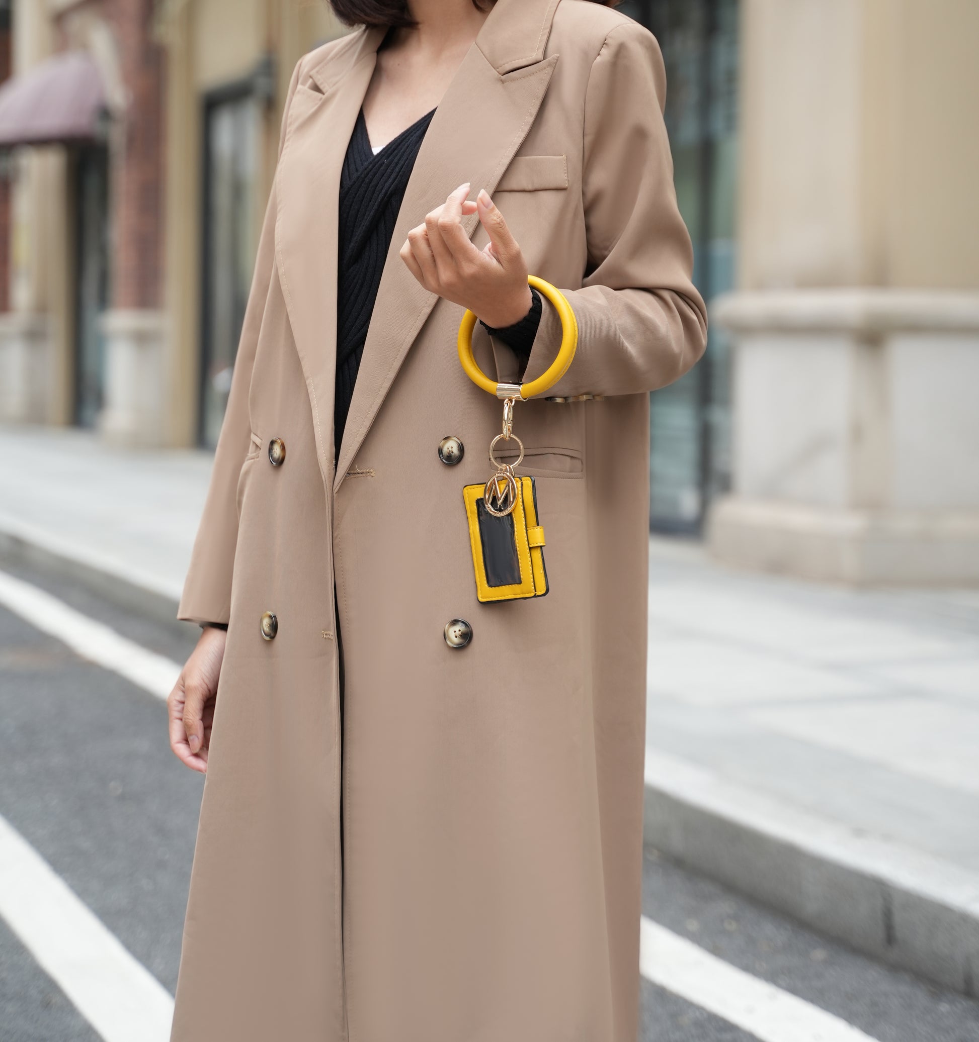 A woman wearing a Mabel Quilted Vegan Leather Women Shoulder Bag with Bracelet Keychain by Pink Orpheus coat and yellow phone holder.
