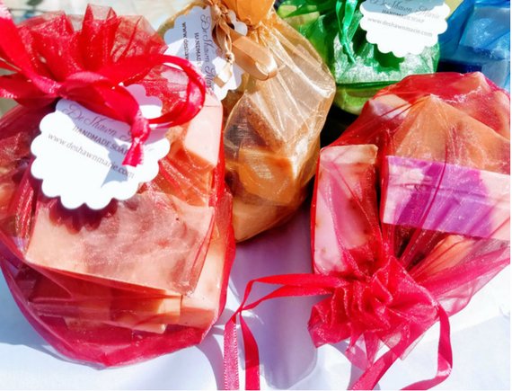 Experience an elevated bath with the Yellow Shadow Assorted Vegan Soap Sampler - 1lb, featuring a variety of handmade soaps in colorful organza gift bags with tags, beautifully displayed on a white surface.