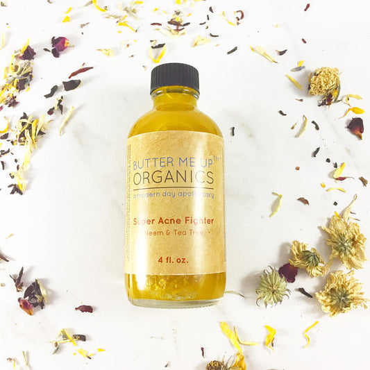 A 4 fl. oz. bottle of White Smokey Organic Acne Treatment with neem and tea tree lies on a white surface, surrounded by scattered dried flower petals—an acne fighting serum that harnesses the power of organic oils for effective skin treatment.