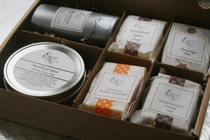 An open gift box containing the Maroon Oliver Just for Him Gift Set, Natural Bath Gift for Men, which includes assorted handmade soaps and a natural aftershave, each item labeled with ingredients and scents.