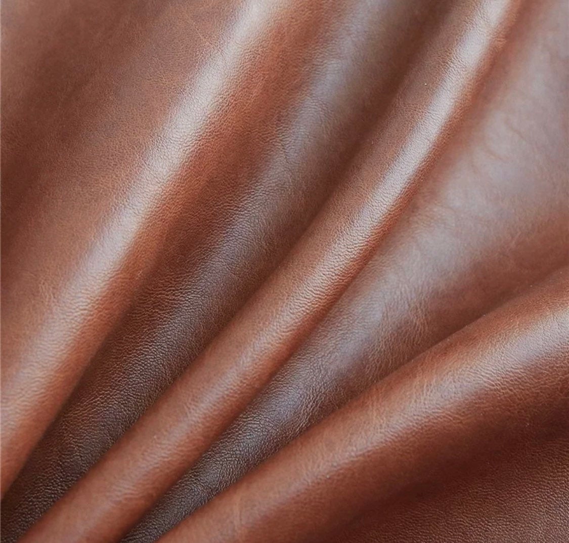 Close-up image of brown Magenta Charlie vegan leather pillow cover with natural texture and soft wrinkles.