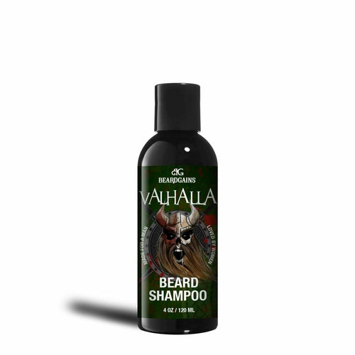 A 4 oz bottle of Valhalla Organic Beard Shampoo by Puce Oliver. This sulfate-free and paraben-free formula features a Viking design on the label, with a split face—one side human and the other a skull—set against a dark background.