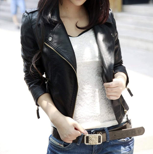 A person wearing a Yellow Pandora Womens Cropped Vegan Leather Jacket over a white lace top and blue jeans with a belt.