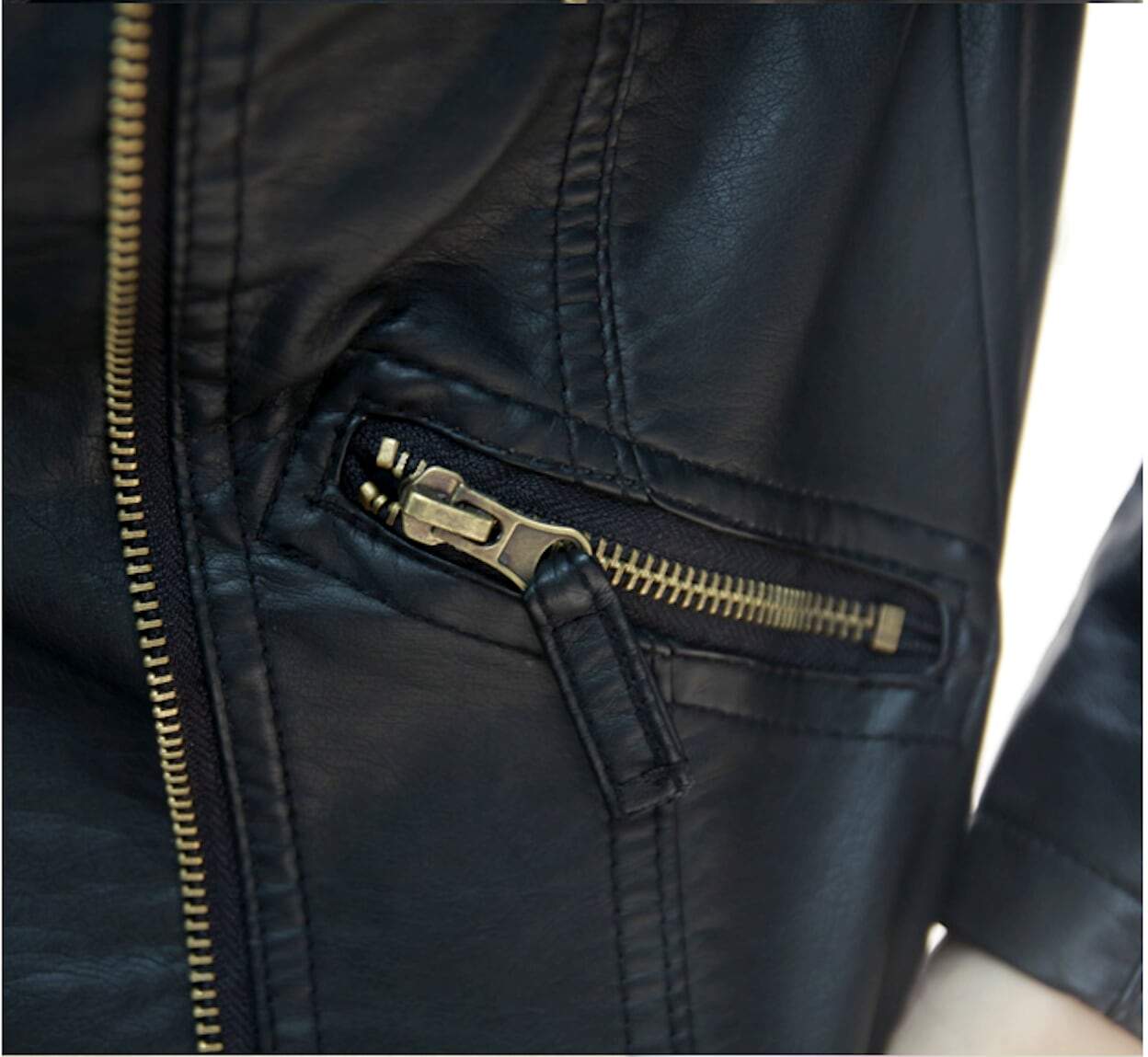 Close-up of a black vegan leather jacket pocket with a partially open gold zipper and a leather zipper pull, showcasing the sleek design of this Yellow Pandora Womens Cropped Vegan Leather Jacket.