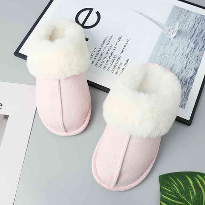 A pair of cozy Trendsi vegan suede center seam slippers in a soft pink color, featuring luxurious fur on top for added comfort.