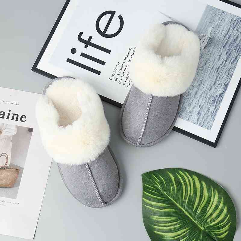 A pair of Trendsi Vegan Suede Center Seam Slippers next to a magazine, offering luxurious comfort.