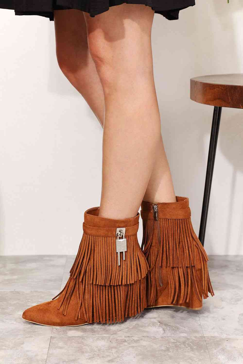 A woman's Legend Women's Tassel Wedge Heel Ankle Booties in a pair of brown fringe boots with an open shank design from Trendsi.