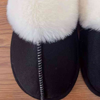 A pair of Trendsi Vegan Suede Center Seam Slippers made of vegan suede on a wooden floor.