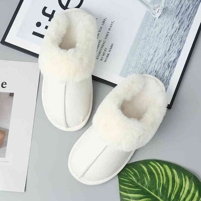 A pair of Trendsi Vegan Suede Center Seam Slippers, known for their comfort, rest on a table.